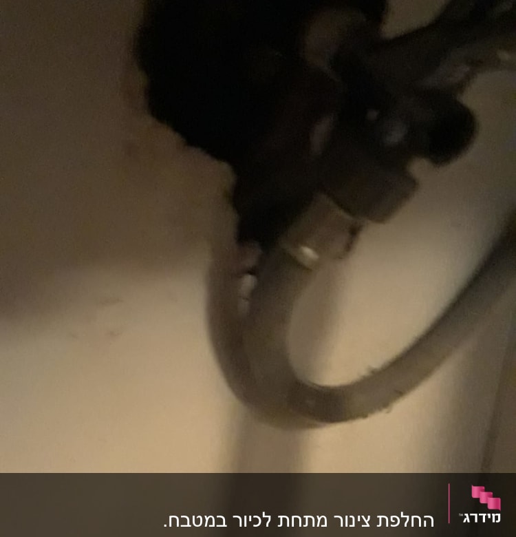 צינור מתכת מחובר לקיר עם חיבורי אינסטלציה